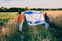 Happy israeli jewish little boys with Israel national flag. Independence Day. Patriotism. Patriot kids, friends on open area field. Symbol of democracy, independence, future. High quality