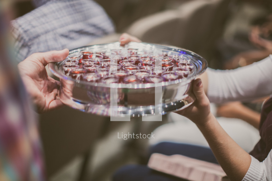 passing a tray of communion cups during a worship service