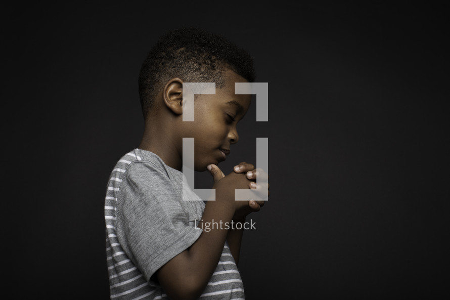 side profile of a boy in prayer 