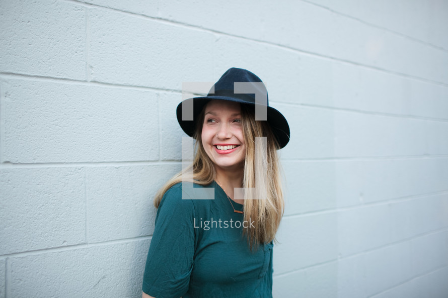 headshot of a woman in a hat smiling 