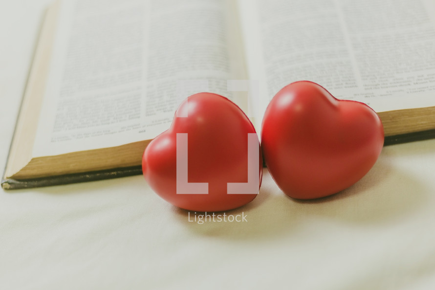two red hearts and an opened Bible 
