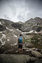 man standing by a mountain lake 