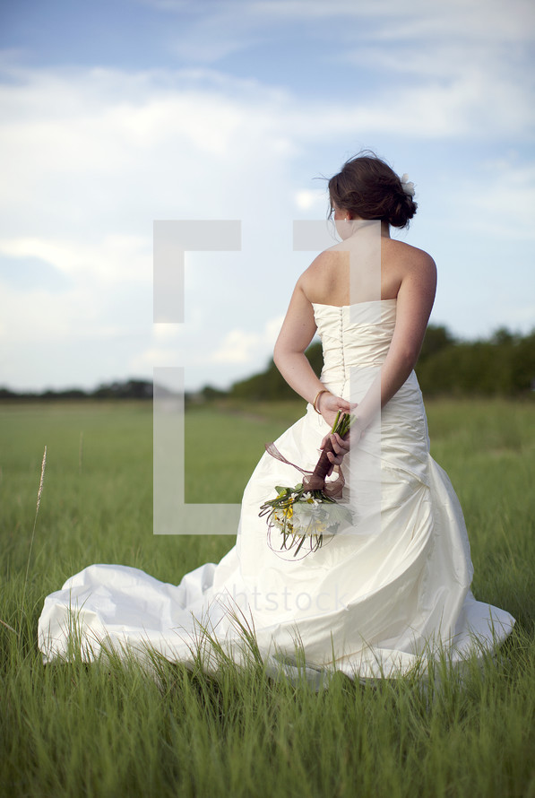 Bride holding bouquet outdoors