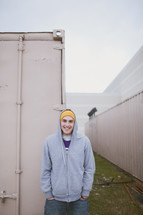 man in a hoodie standing in front of storage units