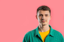 Friendly young man on pink studio background. Copy space. Teenager student guy. High quality photo