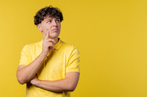 Thinking around man on yellow background. Smart student guy finding answer or trying to remember what he forgot, memory concept. High quality