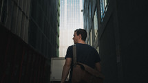 a man with a satchel walking through a city 