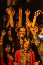 Group worshipping hands raised worship young people youth girl smiling at God