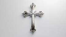 Silver cross jewelry with diamonds set against a white background. 