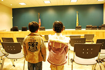 children standing in a city council conference room 