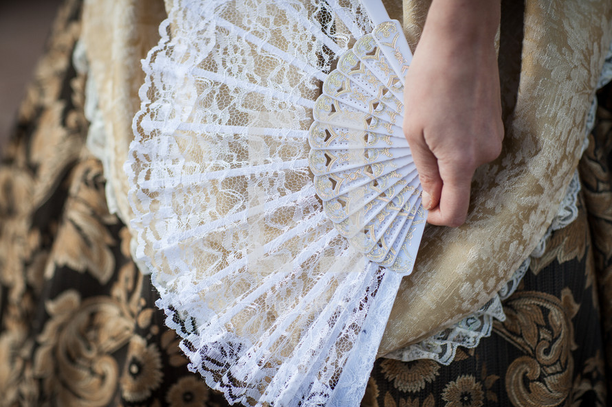 Hand holding a lace fan.