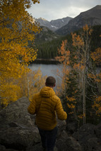 a man walking towards a lake in fall 