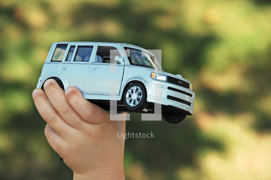 child holding a toy car Scion 