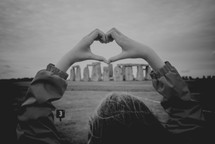 hands forming a heart and view of Stonehenge 