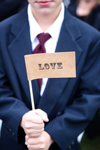 a young man in a suit holding a love flag 