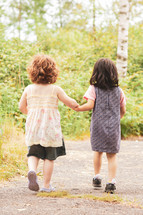 toddler girls walking holding hands 