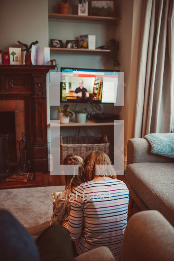 mother and daughter watching a worship service online 