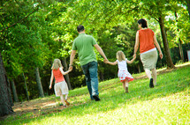 family walking in a park holding hands