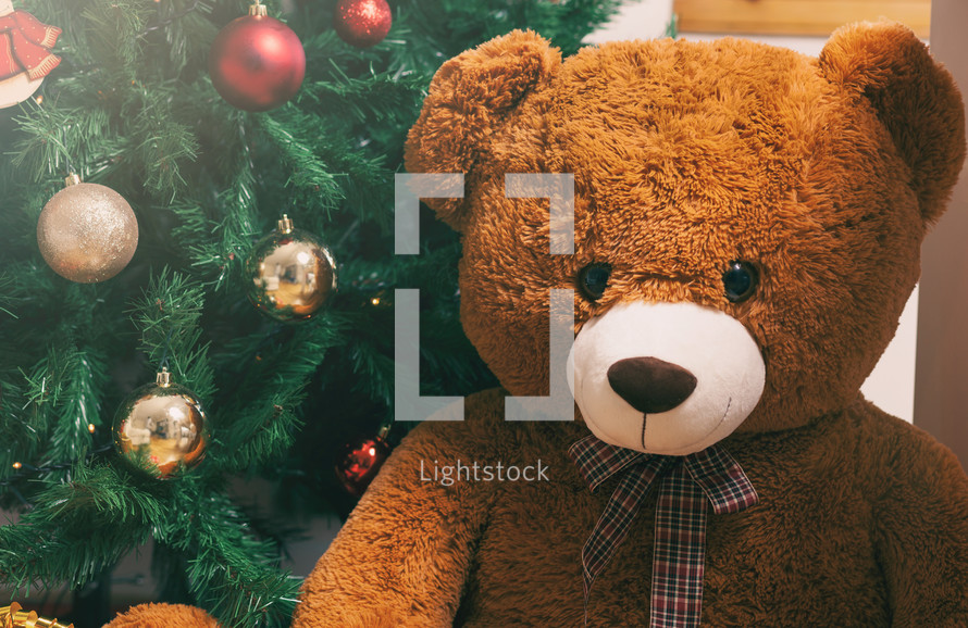 teddy bear under a Christmas tree