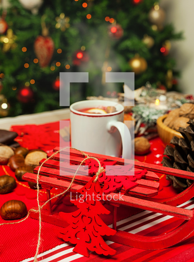 Cup of hot tea on Christmas table with behind Christmas tree