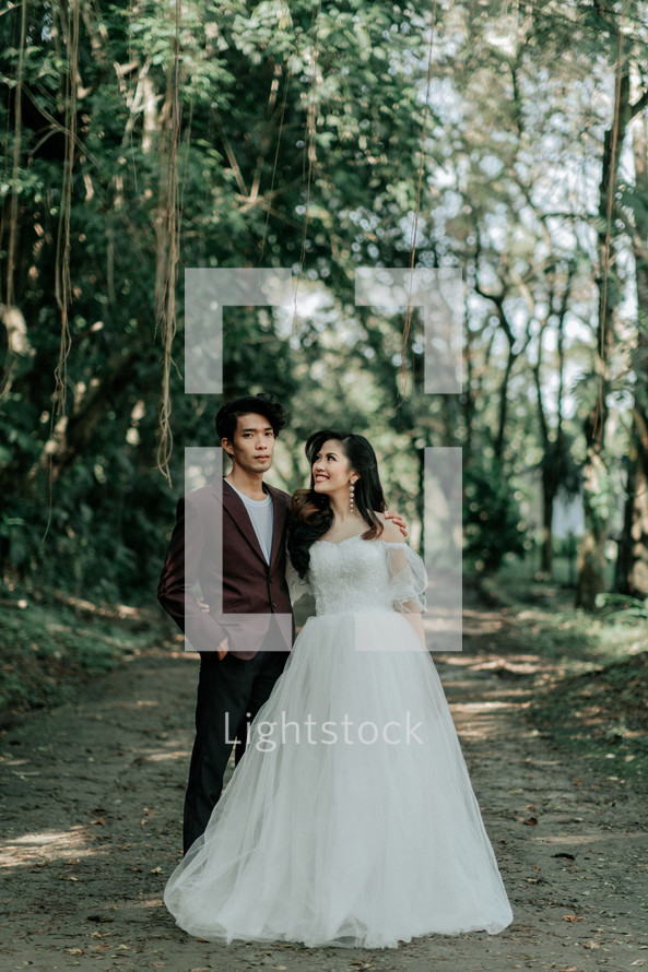 portrait of a bride and groom standing in a jungle 