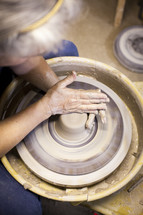 shaping clay on a potter's wheel 