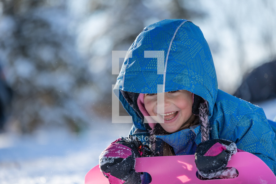 a child with a sled in the snow 