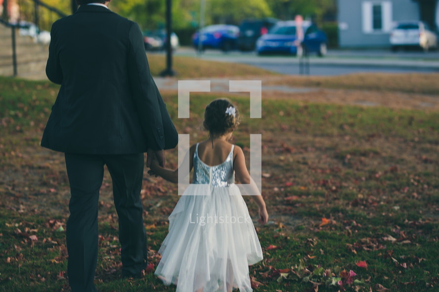 father and daughter walking holding hands 