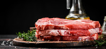 Raw pork steak on a stone board. On a black background. High quality photo