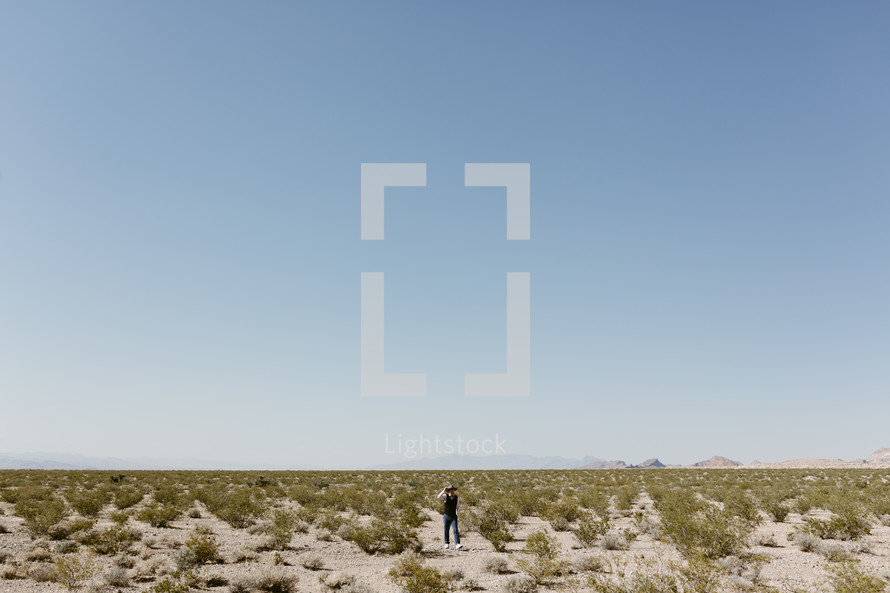 a man walking on a desert landscape in Nevada 
