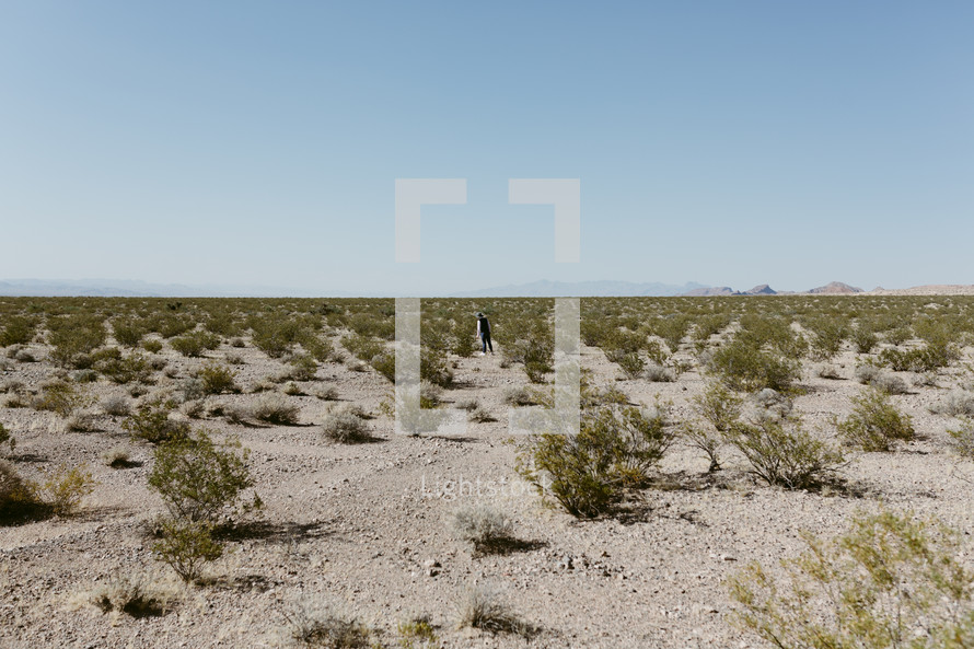 a man walking through a desert landscape in Nevada 