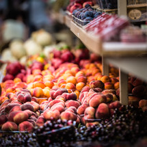 peaches, grapes, plums, and berries at a farmers market 