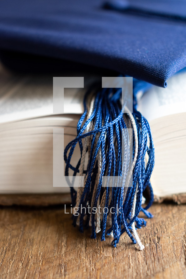 graduation cap on the pages of a Bible 
