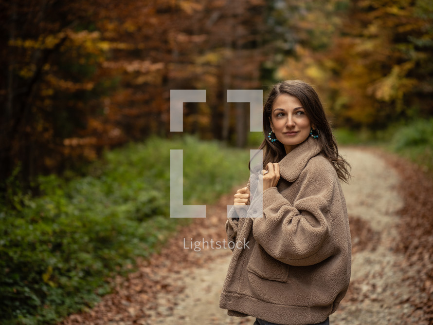 Woman posing on path through fall trees