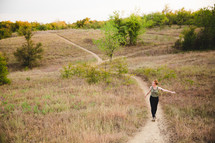 woman walking on a path up a hill 