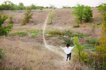 woman running down a hill on a path