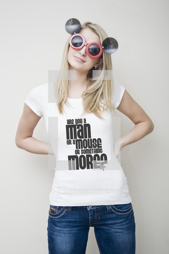 Man or a Mouse; woman with mouse glasses wearing jeans and shirt that reads 'Are you a man or a mouse or something more?'