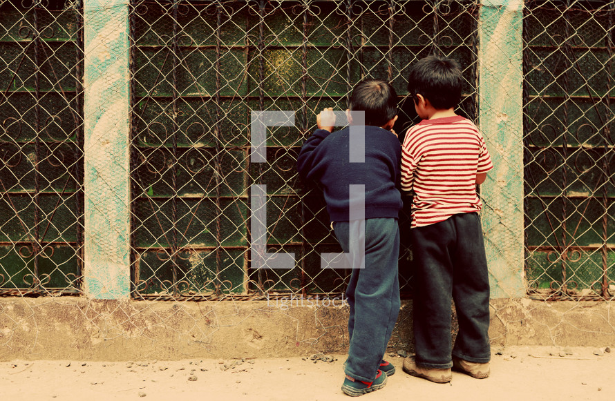 Boys looking through windows with bars