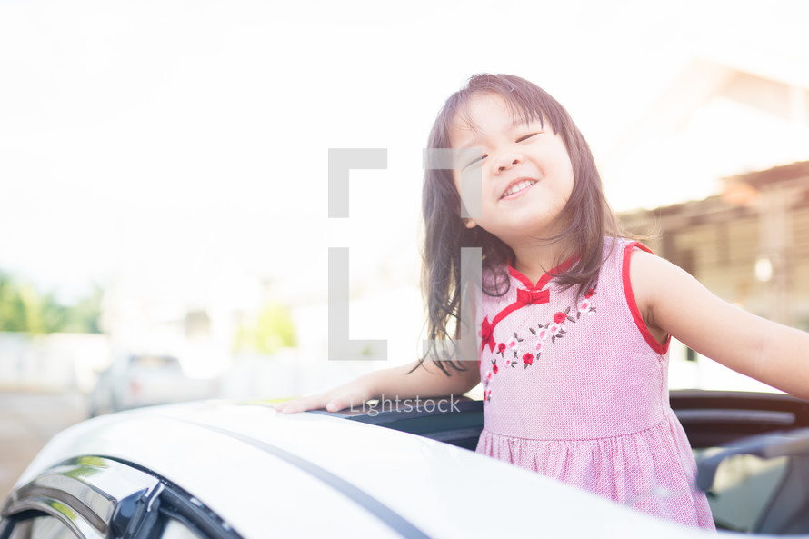 little girl looking out of a sunroof 