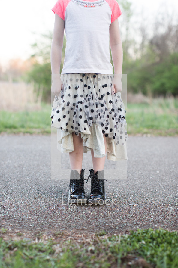 legs of a teen girl in boots and skirt 