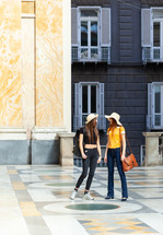 Two young tourists with straw hats in Naples.