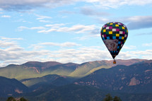 Hot air balloon flying over the mountains of Colorado in the morning light