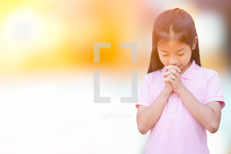 a girl praying outdoors 