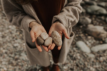 cupped hands holding stones 