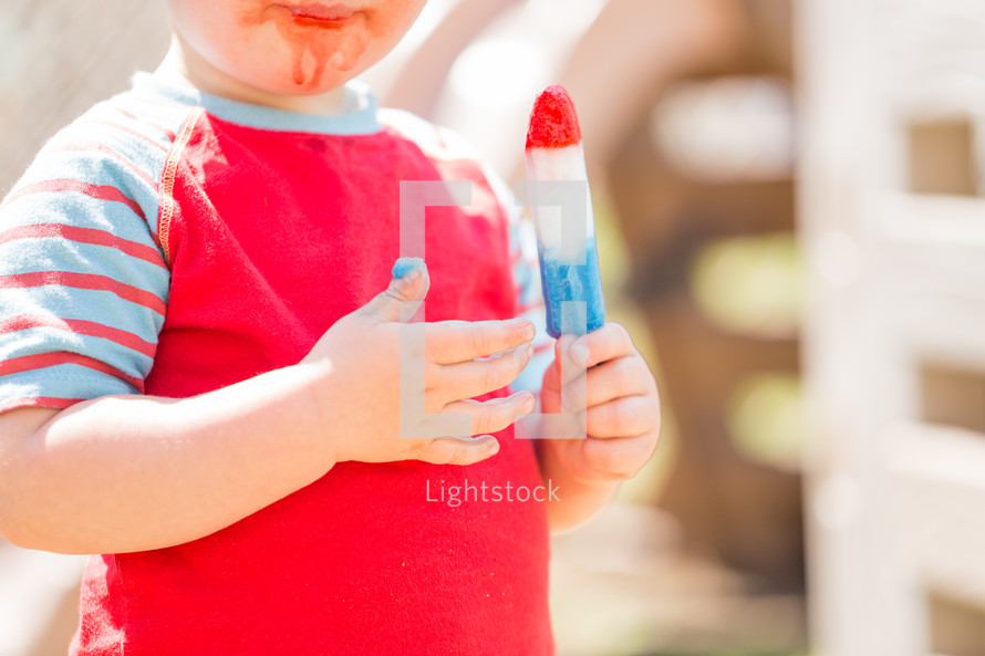 toddler eating a rocket popsicle 