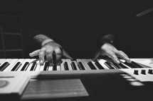 Hands playing a keyboard.