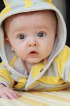 face of an infant boy in a hoodie 