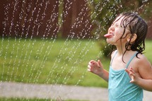 girl child playing in a sprinkler