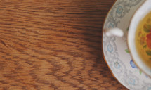 a floral patterned tea cup on wooden table