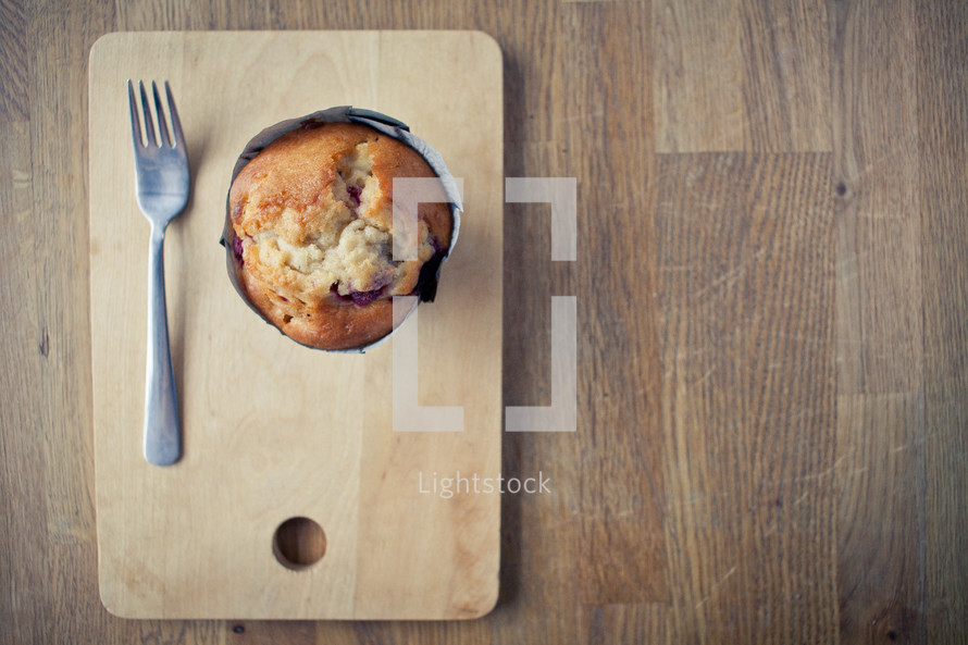 a muffin and a fork on a plate 